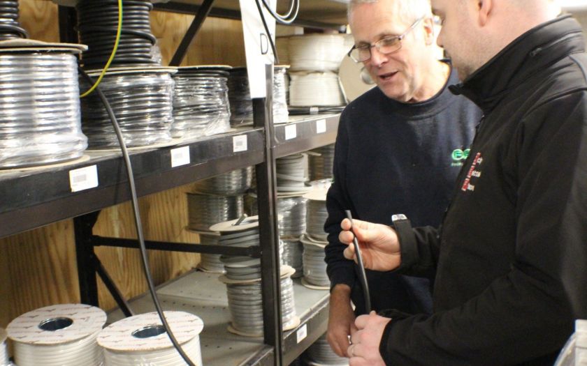Store owner and customer discussing cable quality
