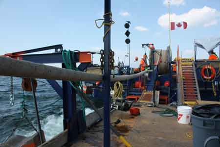 2. The “reel” barge backs up and connects to the cable splicing barge and anchors all four corners, the cable is pulled to the cable splice point and secured.