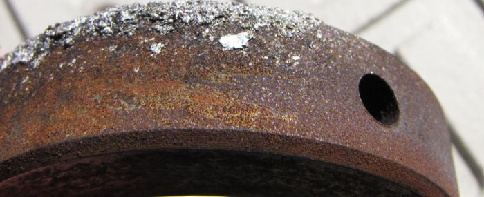 Steel component showing pre-failure (dark) and post failure (light) rust with molten aluminium on top of pre-failure rust.