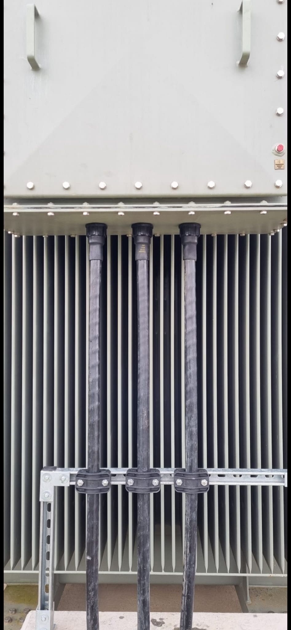Sealed & Supported | The 33kV single core power cables manufactured to BS7870 Standard were sealed at the transformer point of entry using heat shrink cable sealing glands to prevent water ingress and protect against cable damage. The cleats provide mechanical retain to the cable in position and electrical short circuit protection in the event of a fault situation. Sealed & Supported | The 33kV single core power cables manufactured to BS7870 Standard were sealed at the transformer point of entry using heat shrink cable sealing glands to prevent water ingress and protect against cable damage. The cleats provide mechanical retain to the cable in position and electrical short circuit protection in the event of a fault situation.
